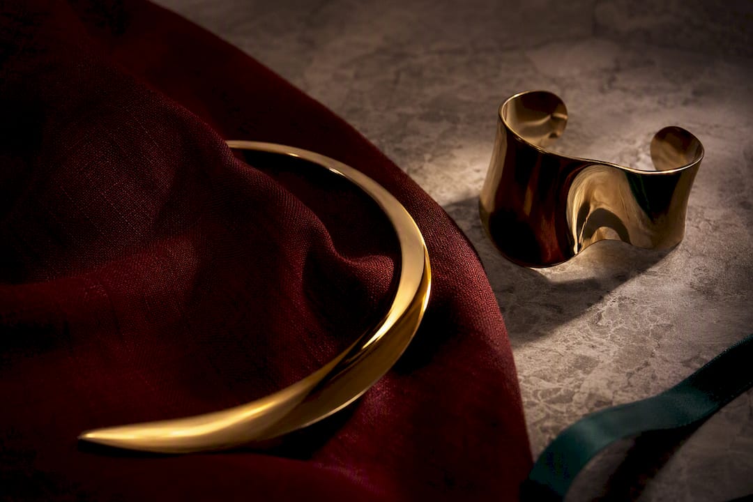 Sculptural metal jewelry in dramatic editorial light