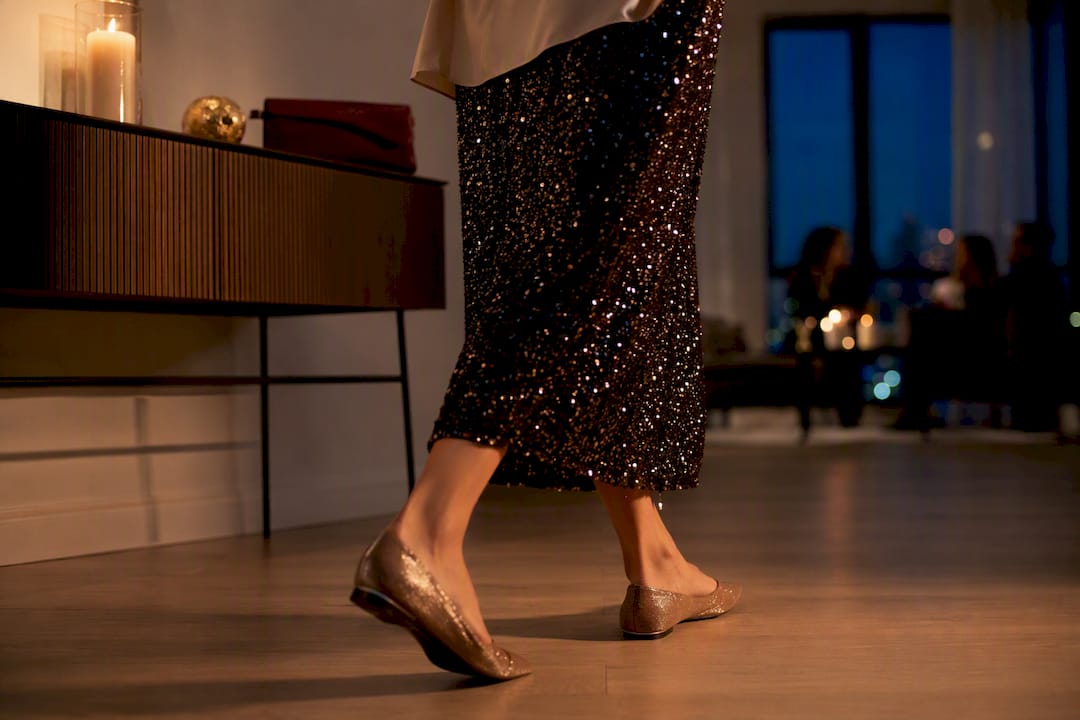 Cropped festive outfit details in party lighting